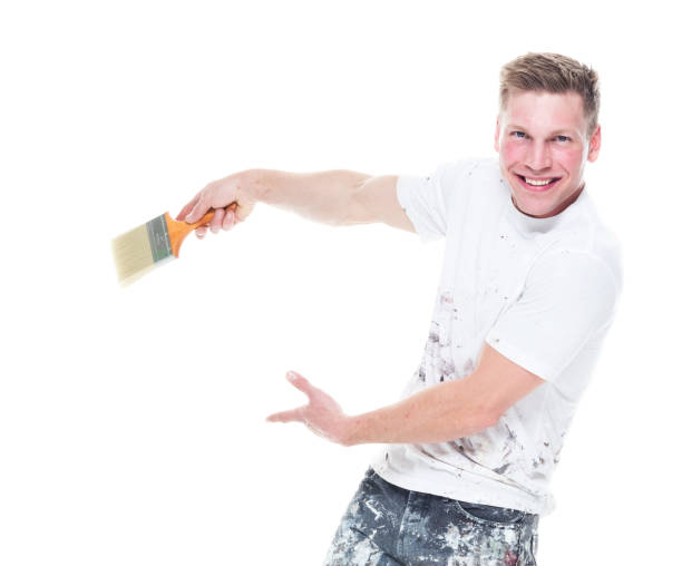 istock Young male painter with stained clothes on white background - looking at camera, showing to the back 1161902899