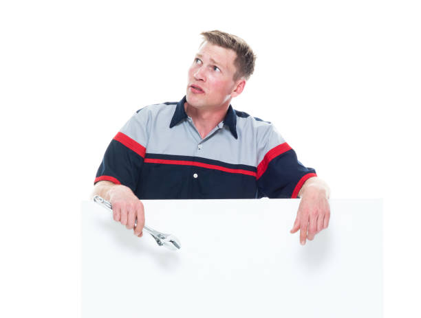 istock Handsome young male mechanic standing next to a big placard - confusion 1161903705