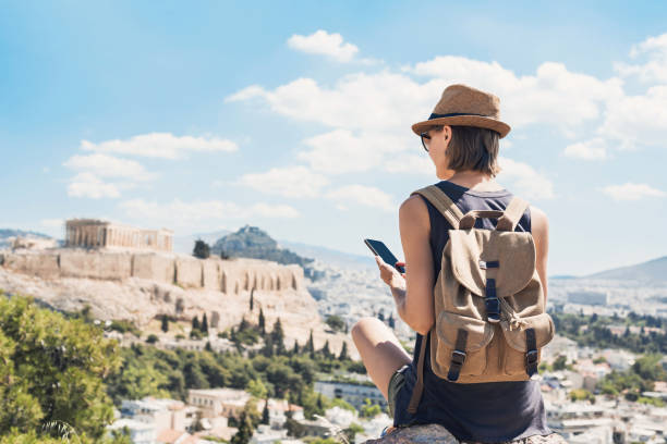 Woman using smart phone on vacations in Athens Young woman traveler using mobile phone outdoor travel destinations stock pictures, royalty-free photos & images