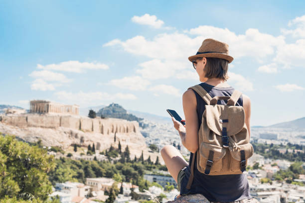 Woman using smart phone on vacations in Athens Young woman traveler using mobile phone outdoor travel stock pictures, royalty-free photos & images