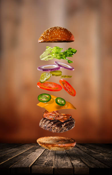 istock Tasty cheeseburger with flying ingredients on dark background 1161914878