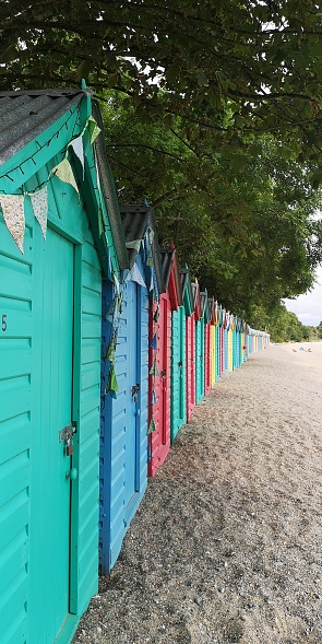 An array of brightly coloured beach huts in Gwynned, Wales.
