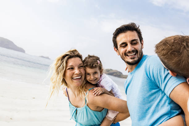 istock Playful family having fun while piggybacking on the beach. 1161920296