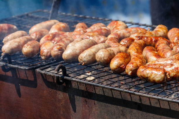 istock Sausages cooking on a grill 1161920571