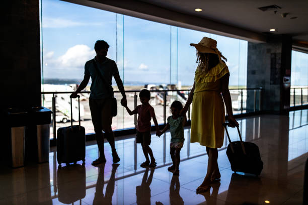 istock Young family talking while walking through airport hallway. 1161920605