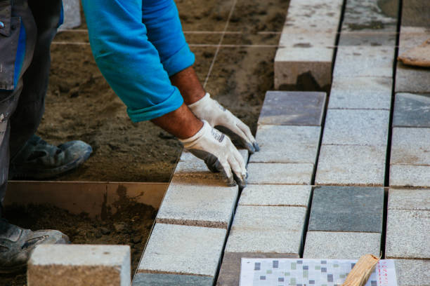 istock Man placing concrete pavement stones as building material 1161922801