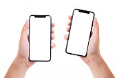 Hands holding two blank white screen smart phones