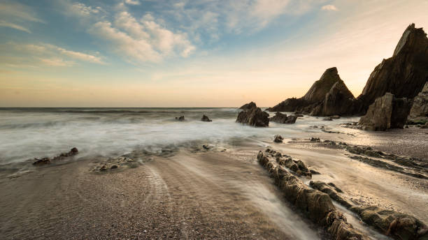 istock Stunning sunset landscape image of Westcombe Beach in Devon England with jagged rocks on beach and stunning cloud formations 1161924703