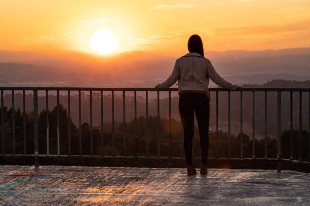 istock Beautiful woman back shot on a viewpoint railing during sunset with blurred background and copy space 1161927553