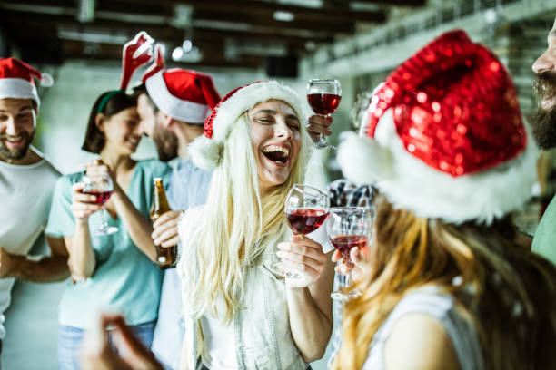 New Year's party in the office! Group of cheerful creative people having fun on Christmas party in the office. Focus is on blond woman. office parties stock pictures, royalty-free photos & images