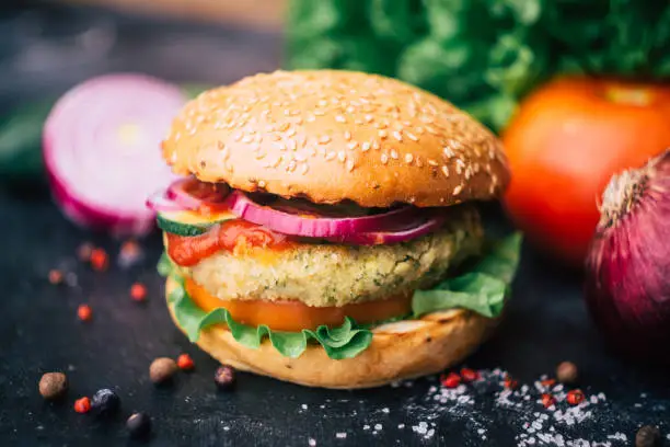 Photo of Vegetarian burger (home made burger) with chickpea cutlet and vegetables. Veg concept. Copy space.