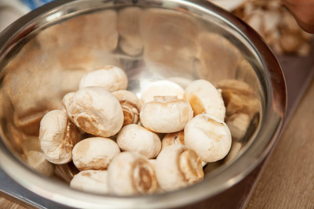 Human Hands Cutting Porcini Mushrooms in Slices
