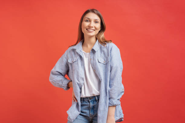 istock Pretty female model posing with a smiling face expression on red background 1161932431