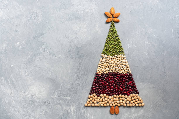 Christmas tree of different beans, chickpeas and almonds on a gray rustic background. The concept of holiday and vegetarian food. Top view, flat lay, copy space. Christmas tree of different beans, chickpeas and almonds on a gray rustic background. The concept of holiday and vegetarian food. Top view, flat lay, copy space red mung bean stock pictures, royalty-free photos & images