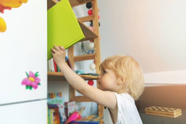 istock child takes book from bookshelf at home 1161936883