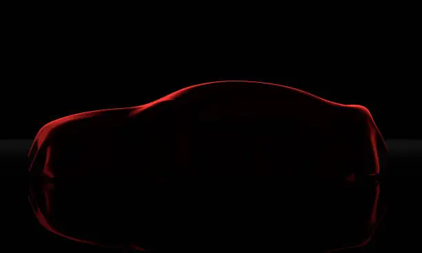 Photo of Car covered with a red cloth isolated on a black background