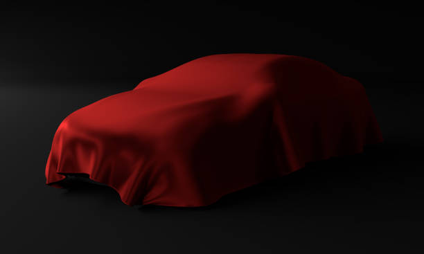 istock Car covered with a red cloth isolated on a black background 1161937072