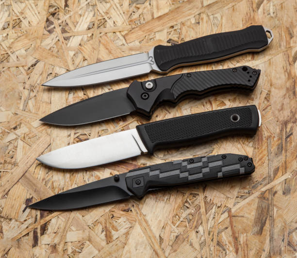 istock Different hunting and penknives on a light wooden background 1161938131