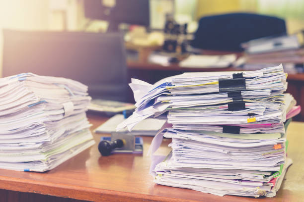 istock Heap of papers work stack documents on office desk ,business documents billing and examination to report the summary results annual report for presented. Business offices concept 1161940020