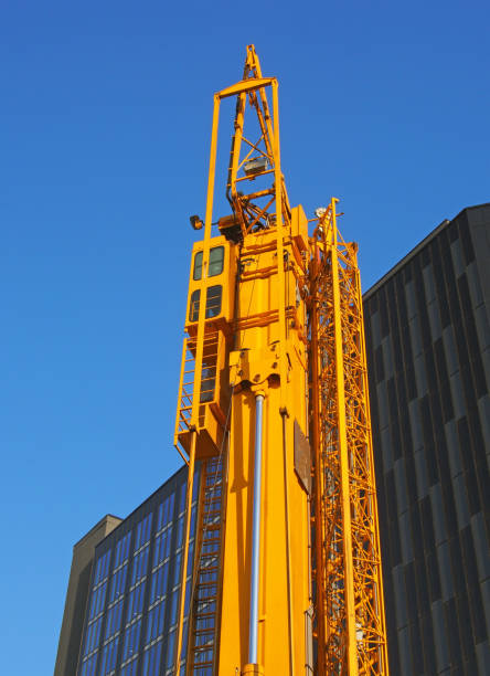 istock a folded yellow construction crane with gantry strapped to the side waiting to be deployed on an urban building site 1161940021