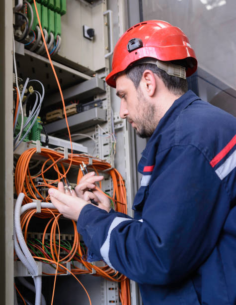光ファイバ ケーブルをスイッチに接続するエンジニア - telecommunications equipment technician repairing engineer ストックフォトと画像