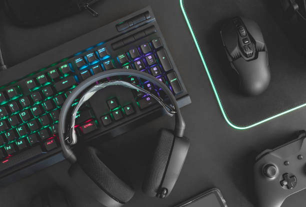 istock e-sport concept, top view a gaming gear, mouse, keyboard, joystick, headset, mobile joystick, in ear headphone and mouse pad on black table background. 1161947117