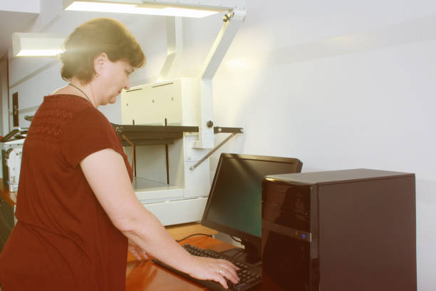 istock Senior Librarian Woman scanning newspapers 1161948255