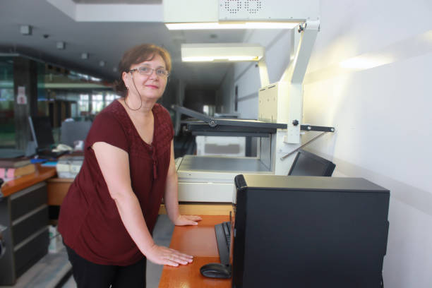 istock Senior Librarian Woman scanning newspapers 1161948566