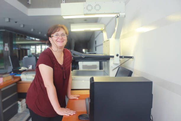 istock Senior Librarian Woman scanning newspapers 1161948672