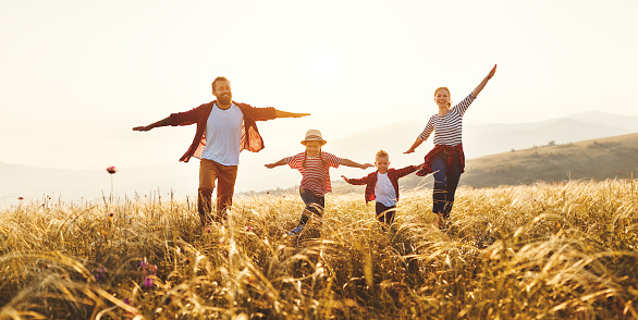 Happy family: mother, father, children son and  daughter on nature  on sunset