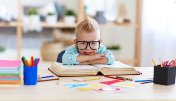 istock funny child  boy  doing homework writing and reading at home 1161952167