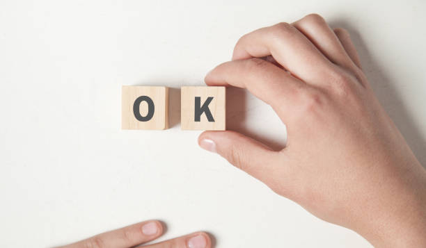 istock Hand showing wooden cube with a word OK. 1161952346