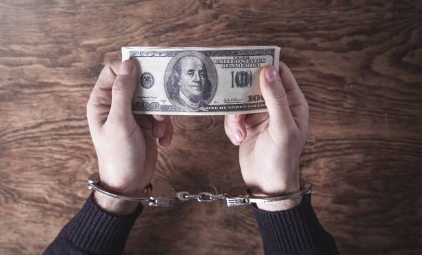 istock Hands in handcuffs holding dollar banknotes. Corruption 1161952359