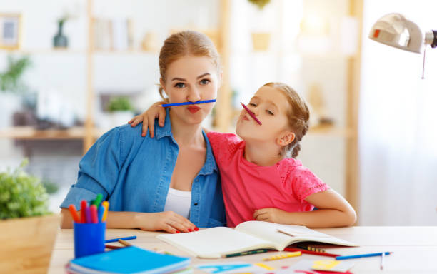istock funny mother and child daughter doing homework writing and reading 1161954632
