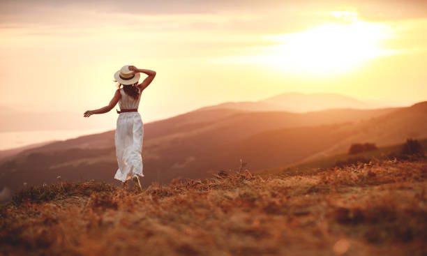 istock Happy woman standing with her back on sunset in nature iwith open hands 1161955464