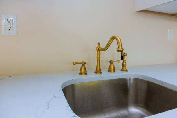 istock Close up of sinks in modern white kitchen with white stone 1161957144
