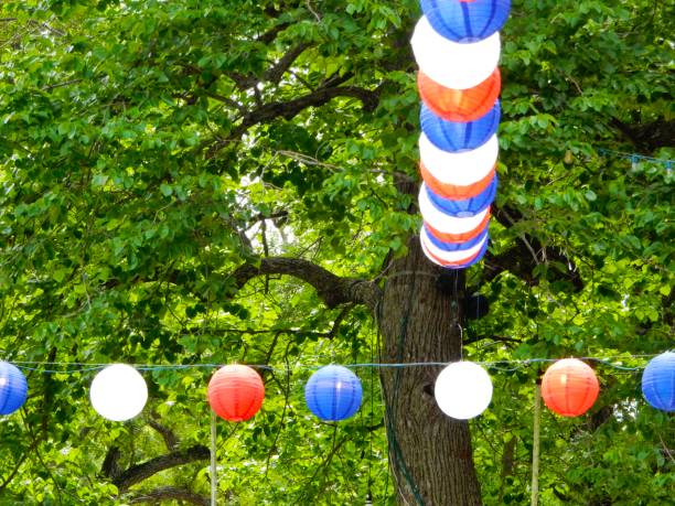 istock Red white and blue paper laterns under green trees 1161963203