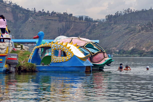 Swimmers warming up behind the moored paddle boats at Lago Yahuarcocha in Ibarra, Ecuador