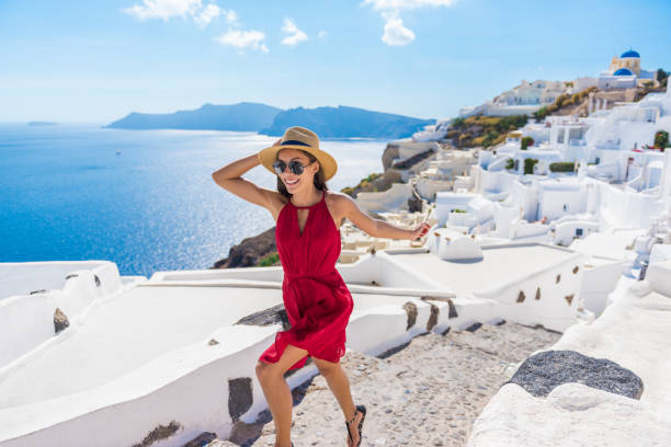 Travel Tourist Happy Woman Running Stairs Santorini Travel Tourist Happy Woman Running Stairs Santorini, Greek Islands, Greece, Europe. Girl on summer vacation visiting famous tourist destination having fun smiling in Oia. greek islands stock pictures, royalty-free photos & images