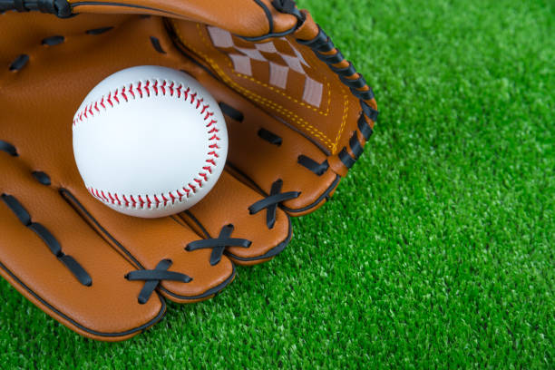 istock Baseball time. Glove and ball on green grass 1161976322