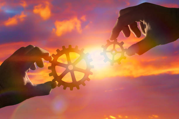 istock Two hands of businessmen assemble gears into a puzzle. 1161976336