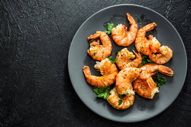 istock Grilled shrimps on plate on dark background 1161981125