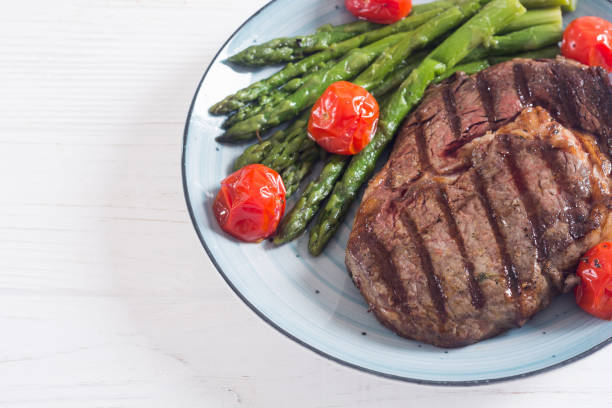 istock Grilled beef steak ribeye with cherry tomatoes and asparagus 1161982513