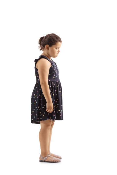 Full length profile shot of a sad little girl looking down isolated on white background