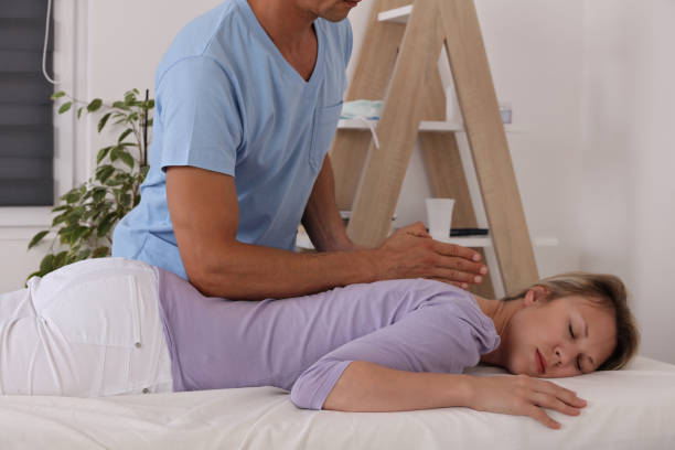 istock Woman having Chiropractic Back Adjustment. Osteopathy, Physiotherapy, Bad posture correction 1161988031