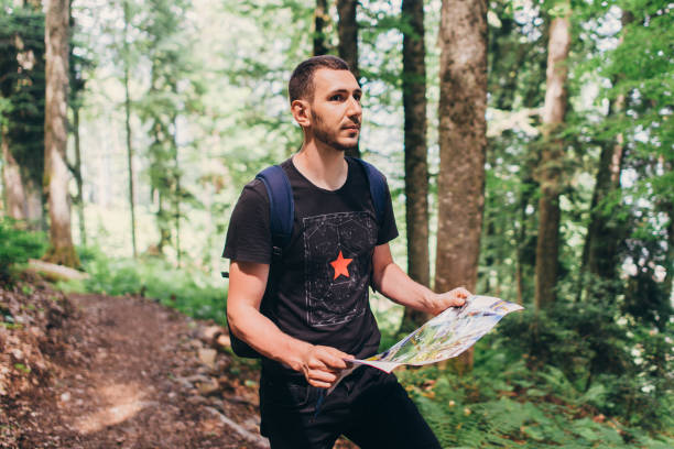 istock Hiker using a map to locate the destination in forest 1161989215