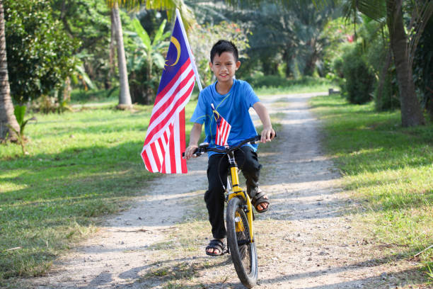 istock A Malay Muslim Boy Riding on a Bicycle With Malaysian Flags 1161989725