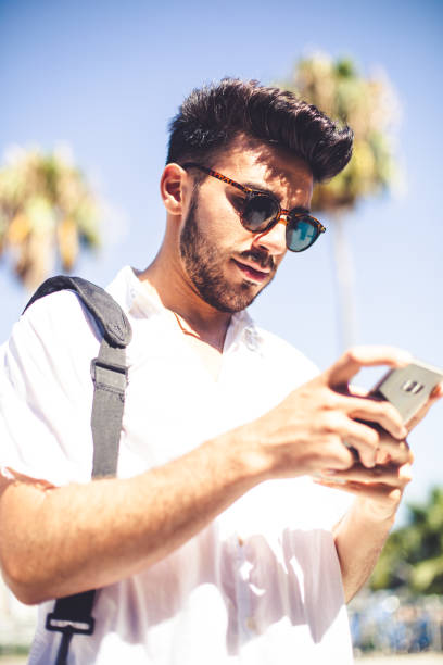 istock Millennial boy checking her mobile phone in a sunny warm day of summer 1161990376