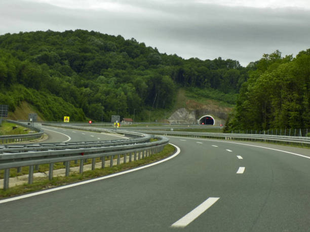 tunnel in beiden richtungen auf der modernen mehrspurigen autobahn - driving industry land vehicle multiple lane highway stock-fotos und bilder