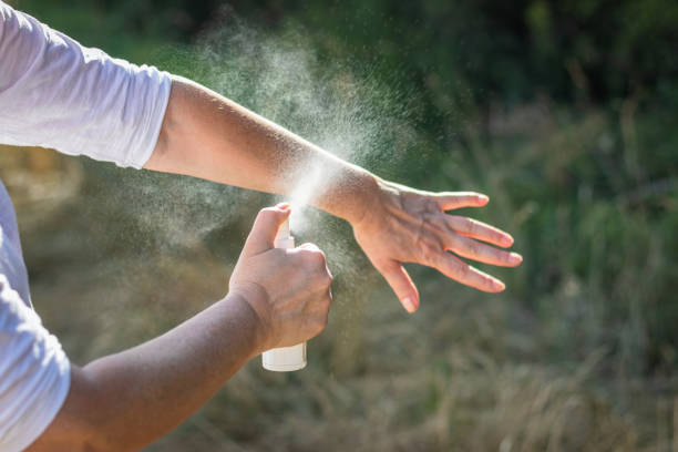 repelente. mujer rociando repelente de mosquitos a mano. - insect repellant mosquito bug bite spraying fotografías e imágenes de stock